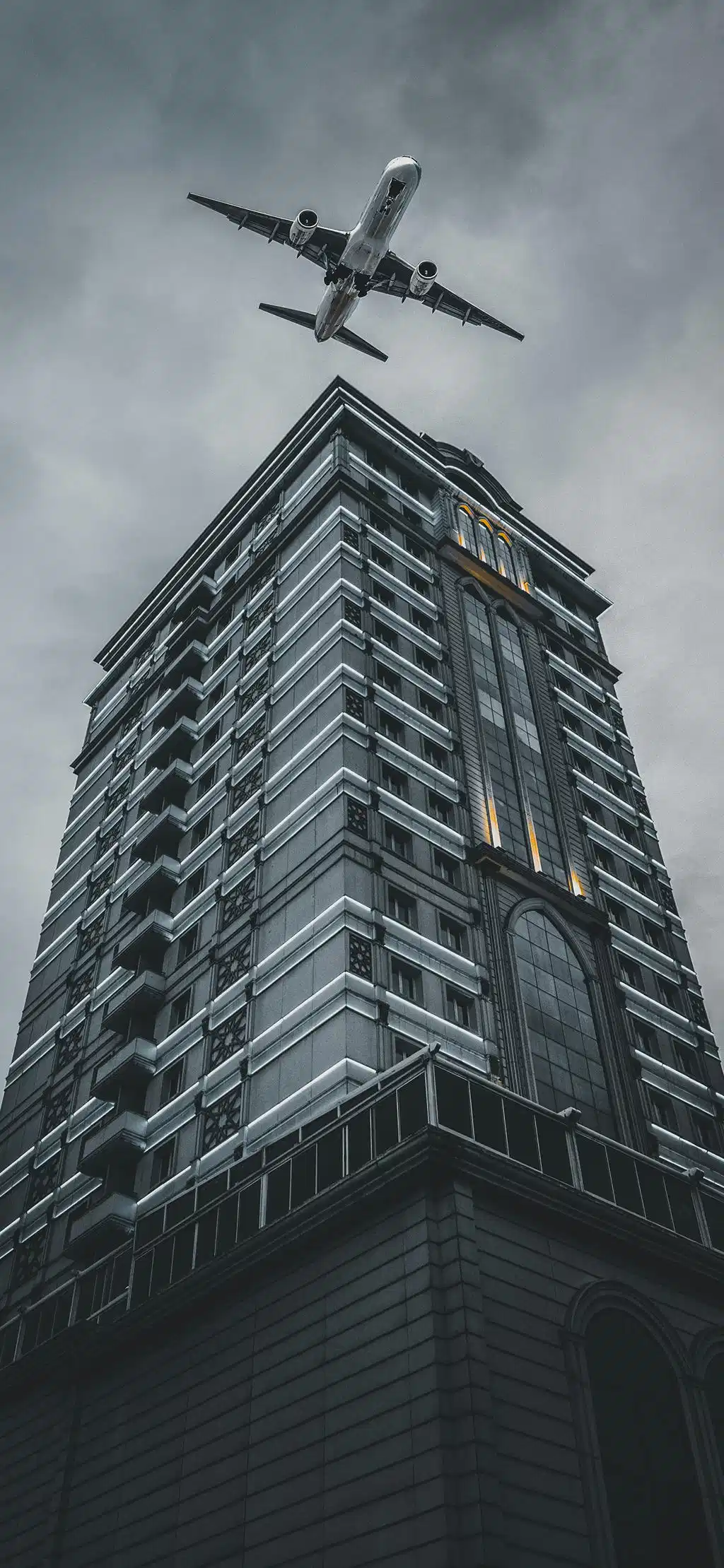 Airplane Flying Above Brutalist Building